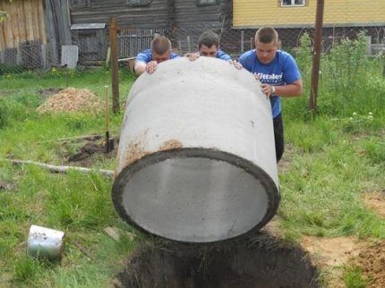 Het installeren van een betonnen ring bij het graven van een put