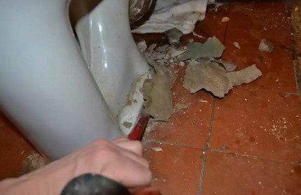 Knocking down cement to dismantle a toilet