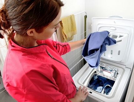 Chargement du linge dans une machine à laver verticale