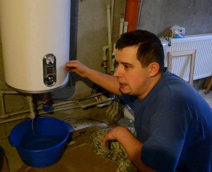 The technician drains water from the boiler