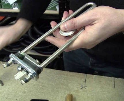 A technician changes the heating element of a washing machine