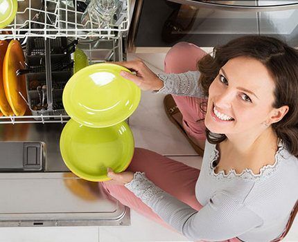 Housewife near the dishwasher