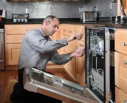 The technician inspects the dishwasher