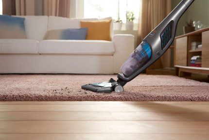 Nettoyer un tapis avec un aspirateur balai