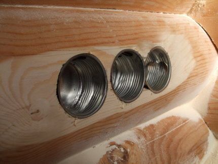 Metalen stopcontactdozen in een houten wand