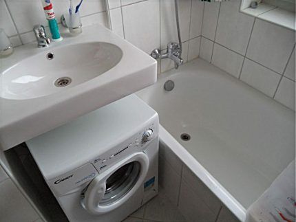 White wall-mounted sink above the washing machine