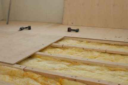 Insulation of a wooden floor with glass wool