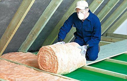 The master lays glass wool insulation