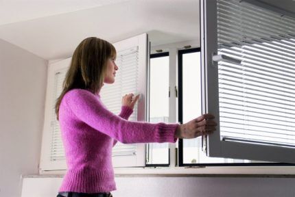 Une femme a ouvert la fenêtre pour aérer