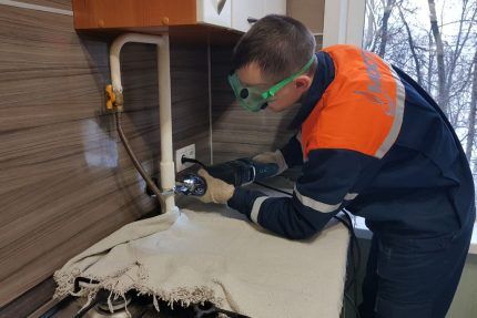 A mechanic repairs a gas pipe