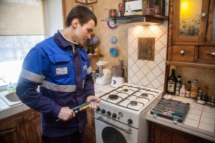 Gas worker repairs stove