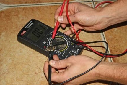 Memeriksa elektrik dandang gas dengan multimeter