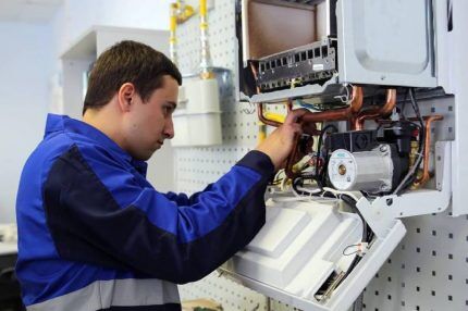 A gas service representative repairs a boiler