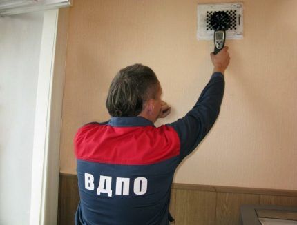 A specialist checking ventilation in a school