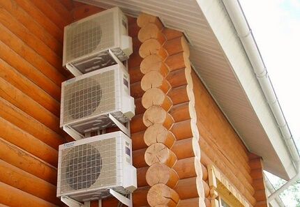 Air conditioners on the facade of a wooden house
