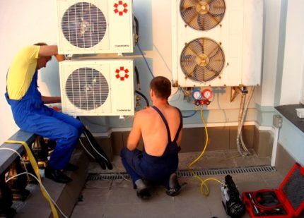 Service center technicians repair a split system