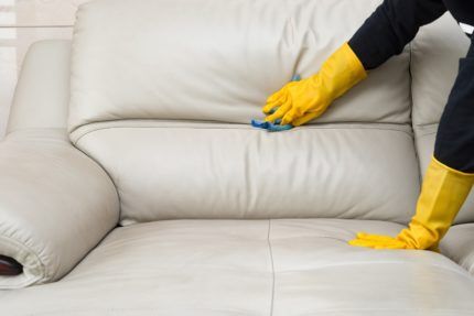 Cleaning a sofa with gloves