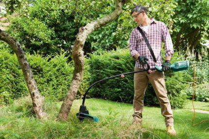 Gras mähen mit einem Trimmer