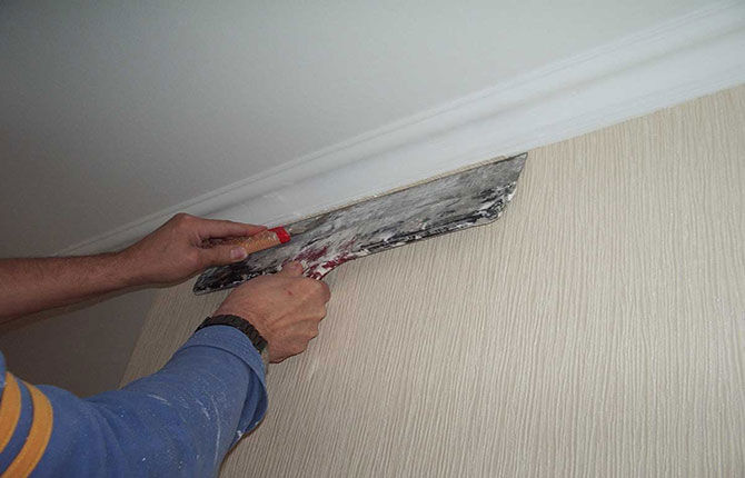 Trimming excess wallpaper on the wall