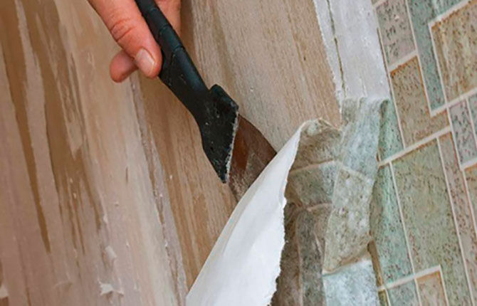 Removing old wallpaper from walls with a spatula