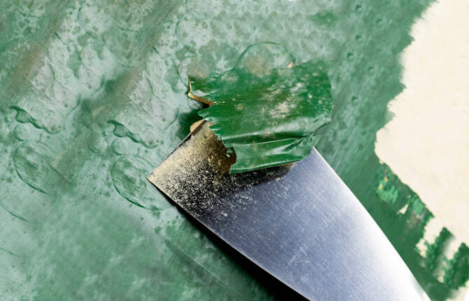 Removing old paint from walls with a spatula